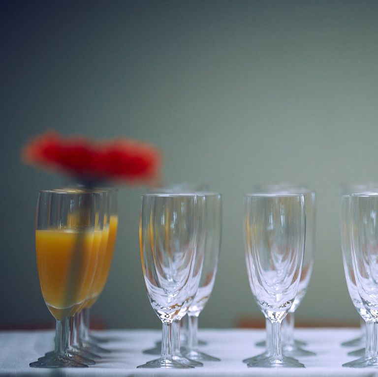Eine Reihe mehrer Sektgläser. Die linken Gläser sind mit Orangensaft gefüllt.